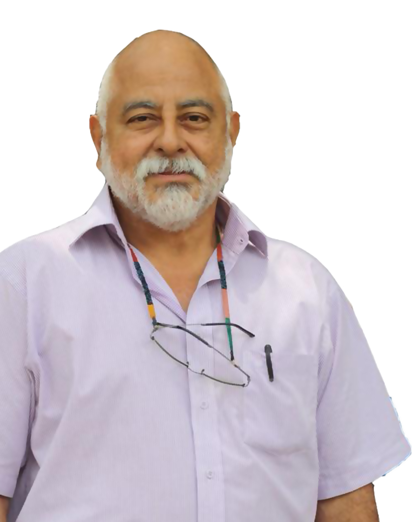 Fotografía del docente con camisa casual y anteojos al cuello. Tiene barba y bigote blanco